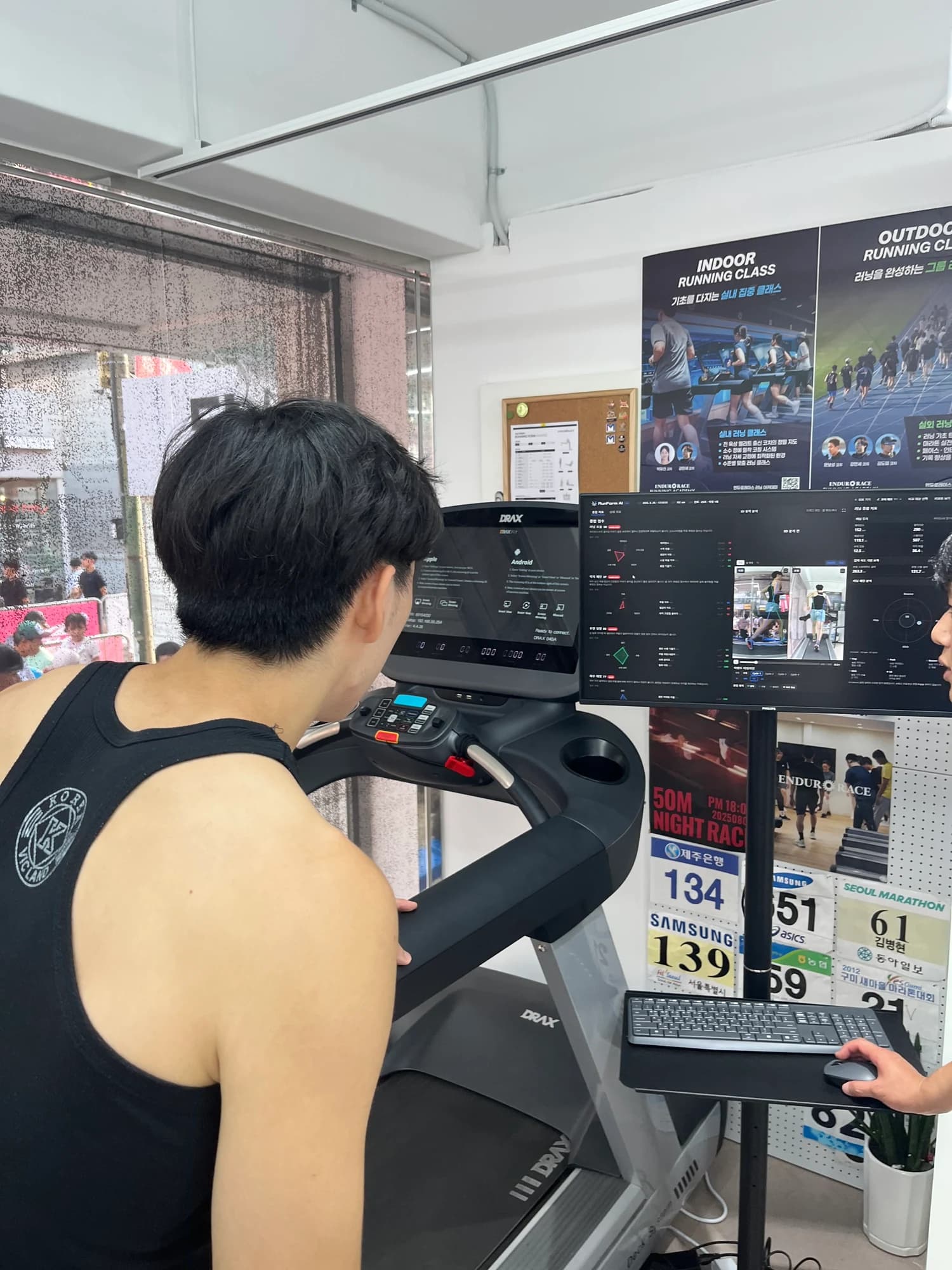 A runner reviews posture analysis metrics on a monitor after running