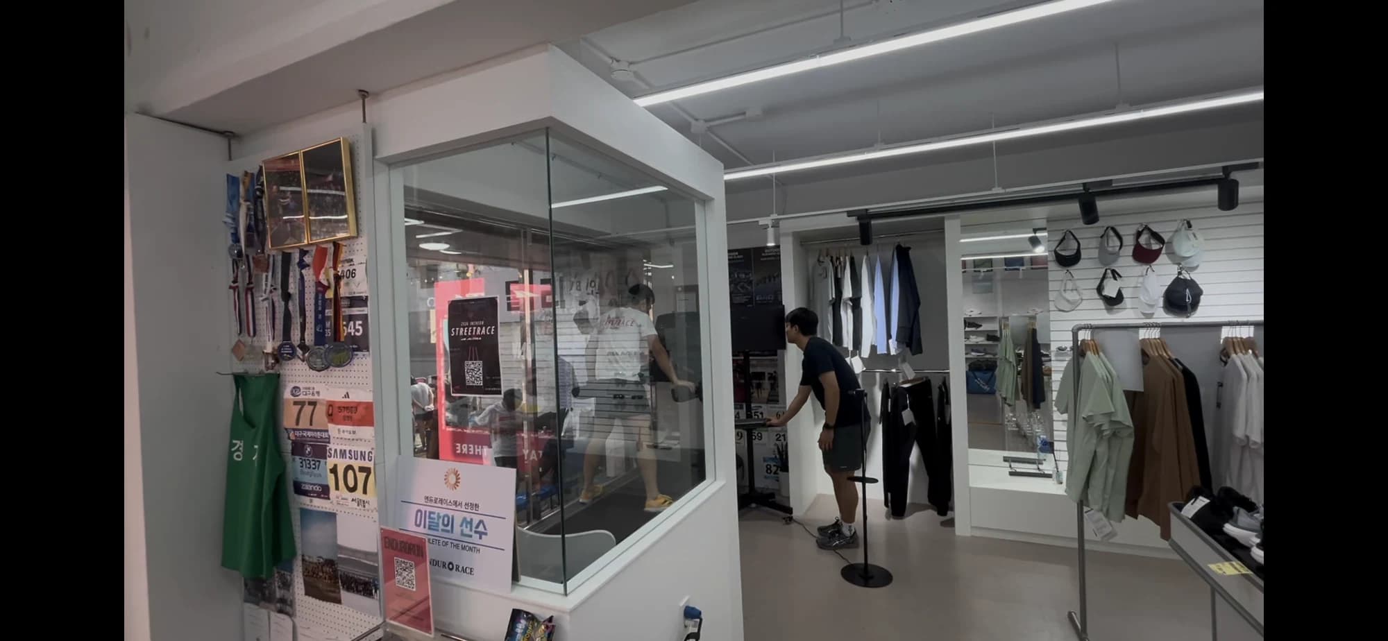 A coach records a runner in an indoor running space